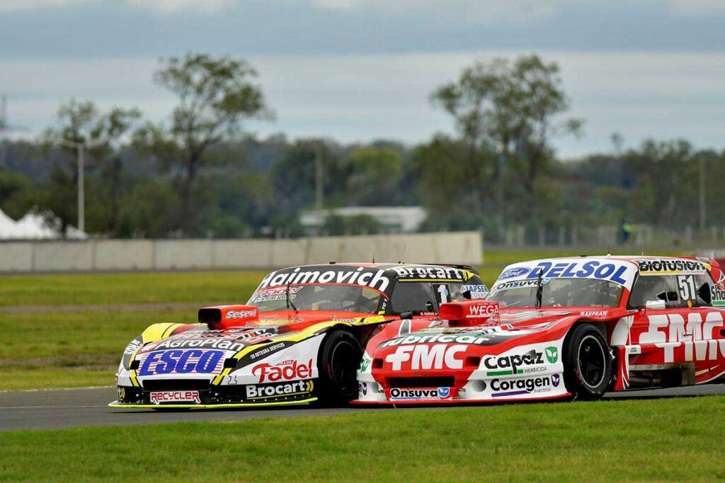 Autos de Gianini y Werner luchando en pista.